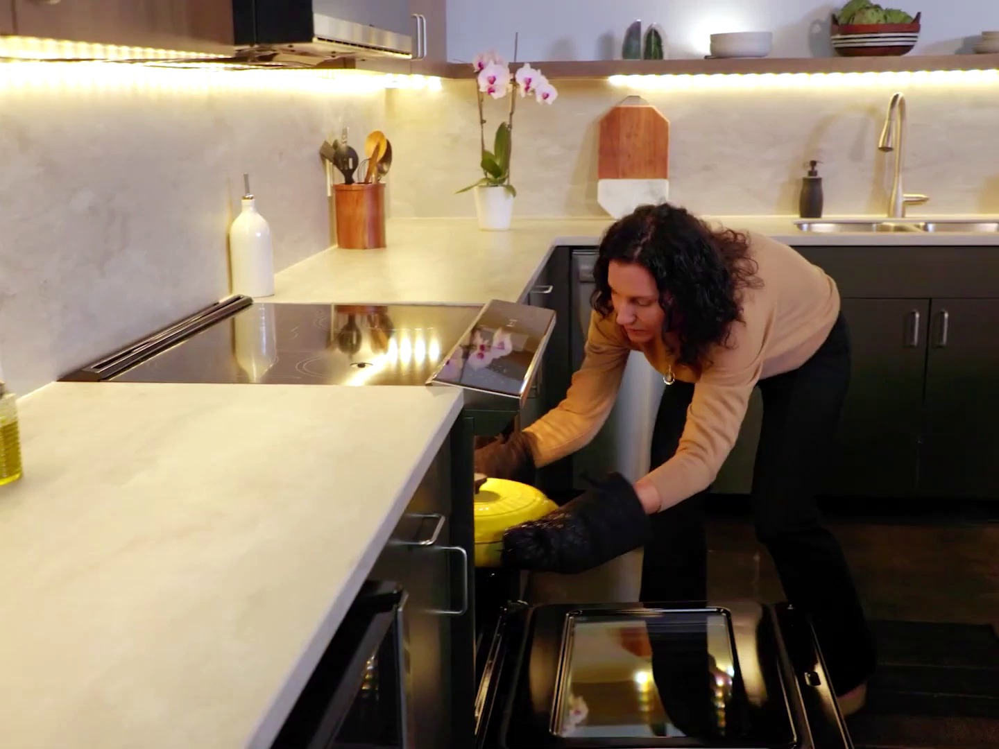 Flavorly AI — woman pulling cooked dish from GE oven in bright kitchen